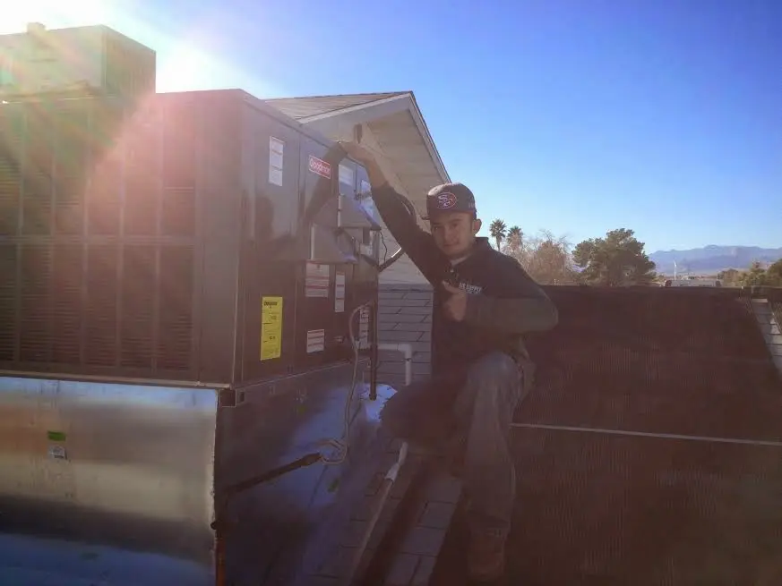 HVAC technician performing AC Tune-Up on a rooftop unit in Fishers
